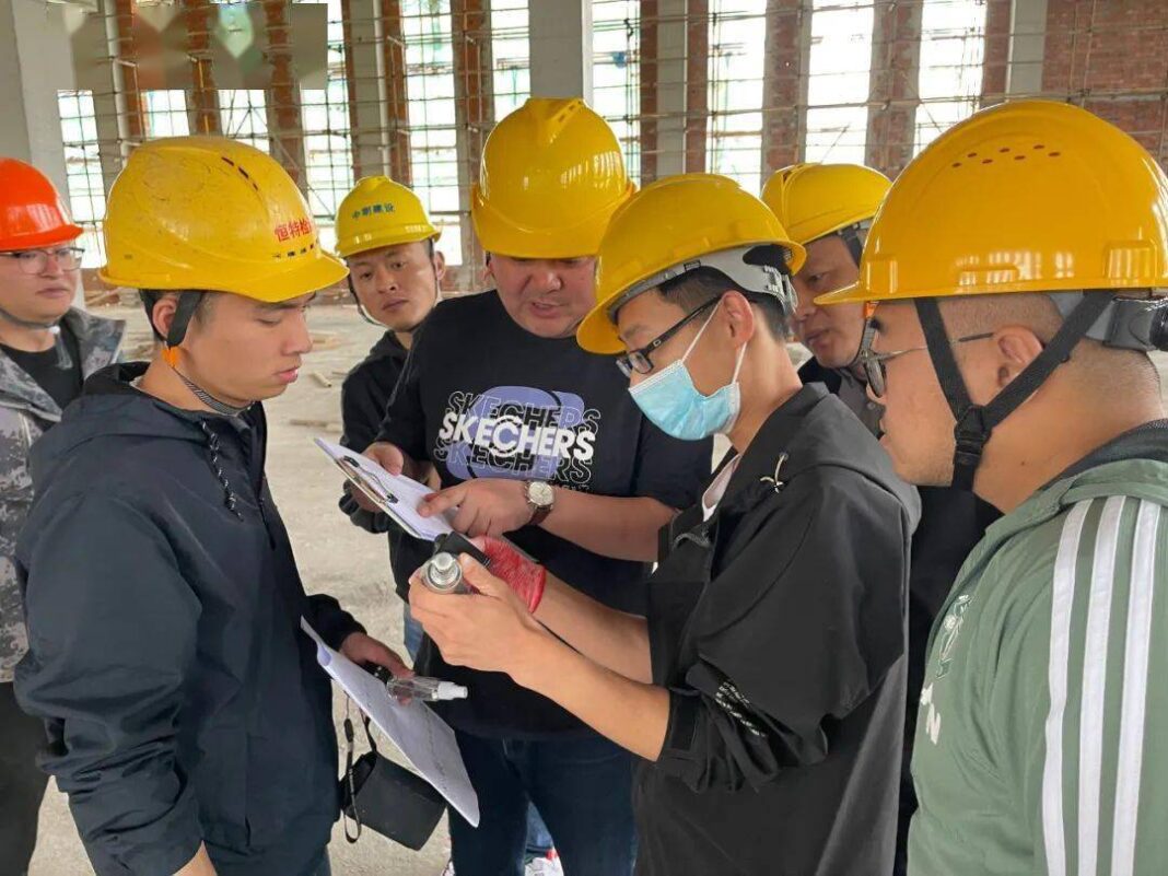 Commercial electrician verifying UL/ETL certification labels on outdoor wall lanterns before installation at a hospitality project site